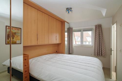 - une chambre avec un grand lit et une fenêtre dans l'établissement WIND 3C strandappartement voor 4 pers bij zeilclub, à Coxyde
