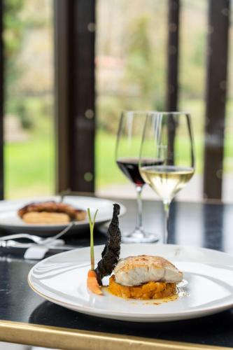 a plate of food and a glass of wine on a table at Parador de Cangas de Onís in Villanueva de Cangas de Onís