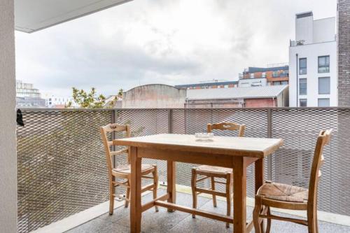 a wooden table and chairs on a balcony at Chambre Double a proximité de Paris in Saint-Denis