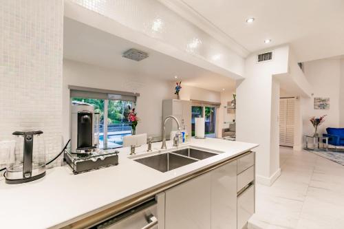 Η κουζίνα ή μικρή κουζίνα στο Uhost AI - Luxurious 5B Home w Pool & Lounge