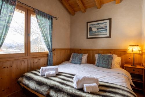 une chambre avec un lit avec des serviettes dessus dans l'établissement Chalet Melusine - Big Chalet w Spa Pool, Sauna, Huge Terrace, Views & Privacy!, à Argentière