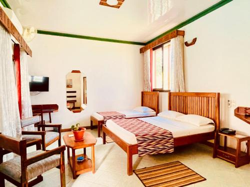a bedroom with a bed and a desk and a chair at LE NOUVEL EDEN in Toliara