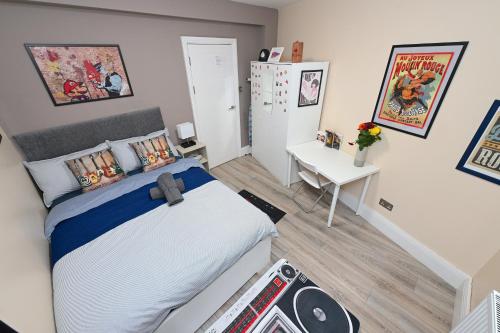 a bedroom with a bed and a desk in it at SUPERB 4 BEDROOM FLAT in THE HEART OF CAMDEN TOWN in London
