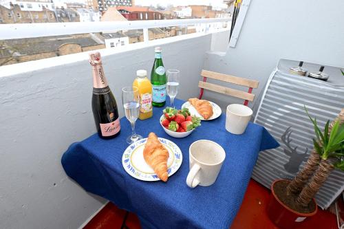 a table with food and drinks and a bottle of champagne at SUPERB 4 BEDROOM FLAT in THE HEART OF CAMDEN TOWN in London