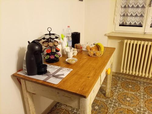 a wooden table with a tea kettle on top of it at Casa Cairo Rooms&Services in Mombaroccio
