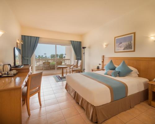 Hurghada Long Beach Resort في الغردقة: غرفه فندقيه بسرير وشرفه