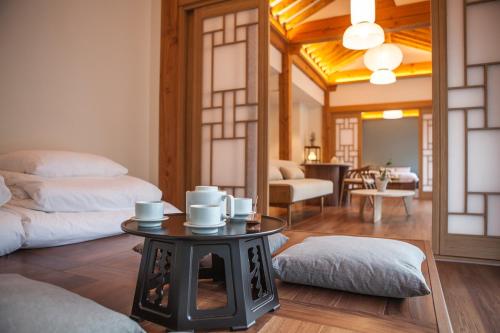 泰安Hotelarrive Taean Tiann HanokBeachResort的客厅里设有桌子和杯子