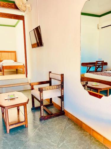 a room with beds and a mirror and a table at LE NOUVEL EDEN in Toliara