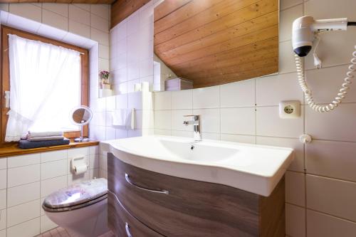 a bathroom with a sink and a toilet at Landhaus Charivari Sommer-Hörnerbahnen kostenlos in Bolsterlang
