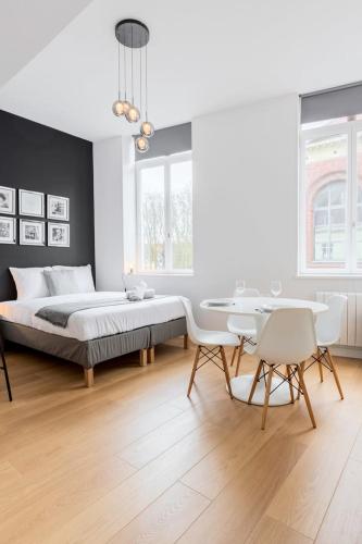 une chambre avec un lit, une table et des chaises dans l'établissement Vieux Lille - Neat and bright apartment, à Lille