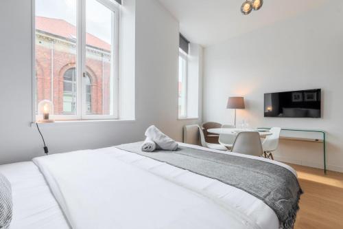 une chambre blanche avec un lit et une table dans l'établissement Vieux Lille - Neat and bright apartment, à Lille