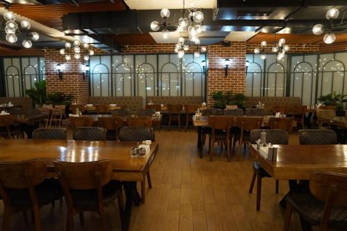 a dining room with wooden tables and chairs at Mihman Hotel in Tuzla