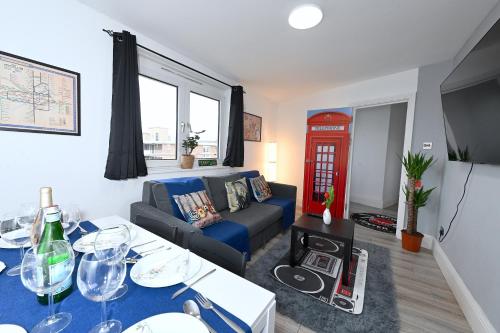 a living room with a blue couch and a red phone booth at SUPERB 4 BEDROOM FLAT in THE HEART OF CAMDEN TOWN in London