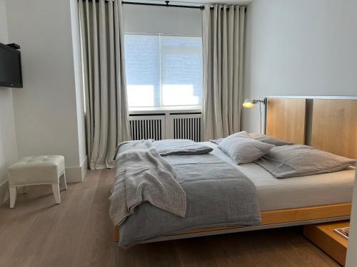 um quarto com uma cama grande e uma janela em Sterflat 97 em Egmond aan Zee