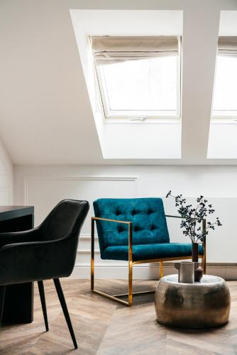 a living room with a blue couch and a chair at Central Palace - LoftAffair Collection in Kraków