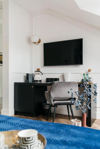 a living room with a chair and a television at Central Palace - LoftAffair Collection in Kraków