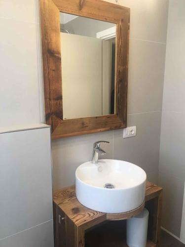 a bathroom with a white sink and a mirror at Apartments in Pur/Ledrosee 22640 in Mezzolago