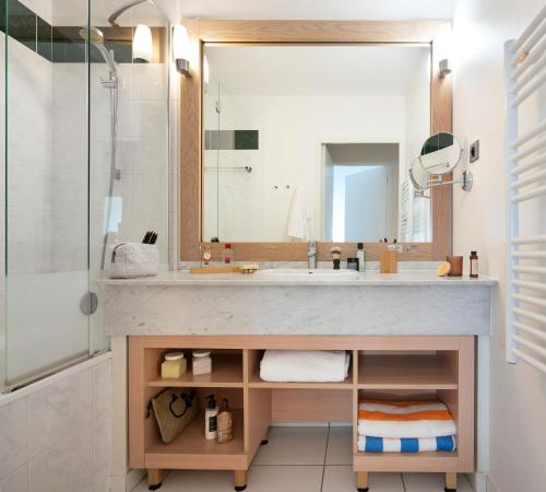a bathroom with a sink and a shower at Résidence Pierre & Vacances Premium Le Domaine de Cramphore in Le Pouliguen
