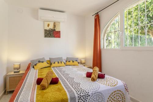 una camera da letto con un letto con cuscini gialli e una finestra di Villa Piscine à la Fustera, Benissa a Benissa