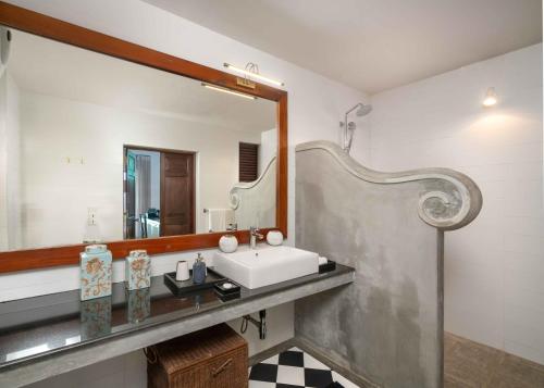 ein Bad mit einem Waschbecken und einem Spiegel in der Unterkunft Taru Villas Kandy in Kandy