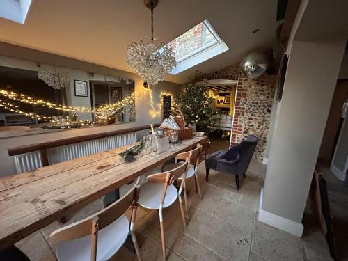 a dining room with a long wooden table and chairs at Stone Cottage in Norwich
