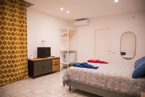 um quarto com uma cama e uma cómoda com uma televisão em Dimore Dalle Zie em Alberobello