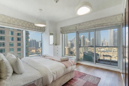 een slaapkamer met een groot bed en grote ramen bij Burj Views Tower 2, Downtown- 2BR Apartment - Allsopp&Allsopp in Dubai