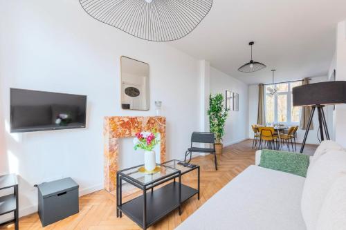 a living room with a couch and a fire place at Charming through-apartment renovated and equipped! in Marcq-en-Baroeul