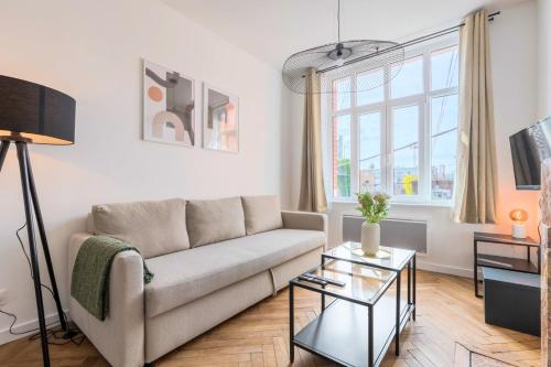 un salon avec un canapé et une table dans l'établissement Charming through-apartment renovated and equipped!, à Marcq-en-Barœul