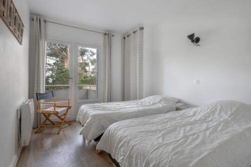 une chambre avec deux lits et une fenêtre dans l'établissement Séjour à 4 - Les pied dans l'eau - Vue mer, à La Baule