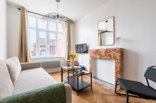a living room with a couch and a fireplace at Charming through-apartment renovated and equipped! in Marcq-en-Baroeul
