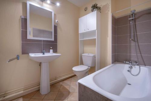 a bathroom with a sink and a tub and a toilet at Appartement face mer pour 4 a Saint Brevin L Ocean in Saint-Brevin-les-Pins