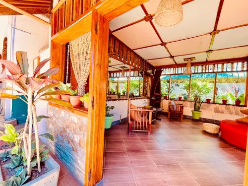 a living room with a red couch and some plants at LE NOUVEL EDEN in Toliara