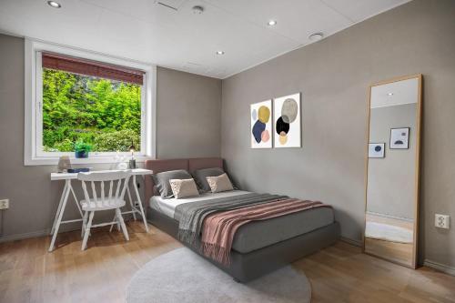 a bedroom with a bed and a table and a window at Apartment with Private Balcony and Flexible Check In in Bergen