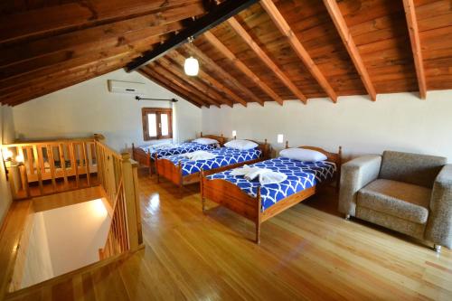 a bedroom with two beds and a couch and a chair at Kilim Kaya Villas in Kınalı