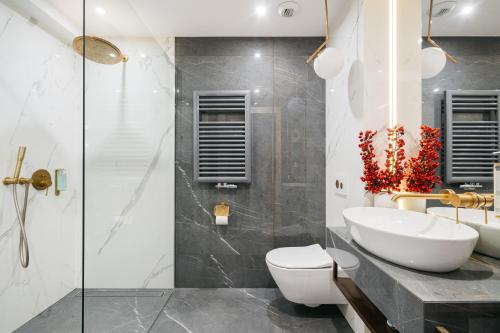 a bathroom with a sink and a toilet and a shower at Central Palace - LoftAffair Collection in Kraków