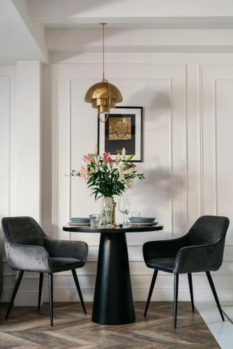 a dining room table with two chairs and a vase of flowers at Central Palace - LoftAffair Collection in Kraków