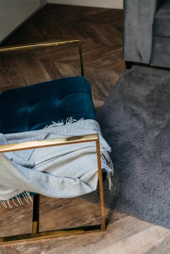 a blue chair with a blanket on a wooden floor at Central Palace - LoftAffair Collection in Kraków