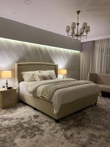 una camera con un grande letto e un lampadario a braccio di بيت عطلات مفروش بالخبر a Al Khobar