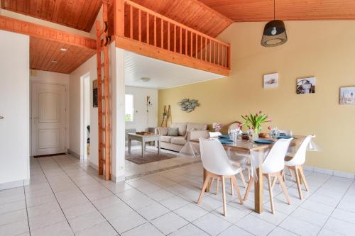 une salle à manger et un salon avec une table et des chaises dans l'établissement L'épine - Vue jardin - 3 Chambres, à LʼÉpine