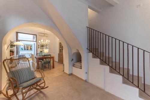un corridoio con una scala con una sedia e una sala da pranzo di Casa Azul by Hello Homes Sitges a Sitges