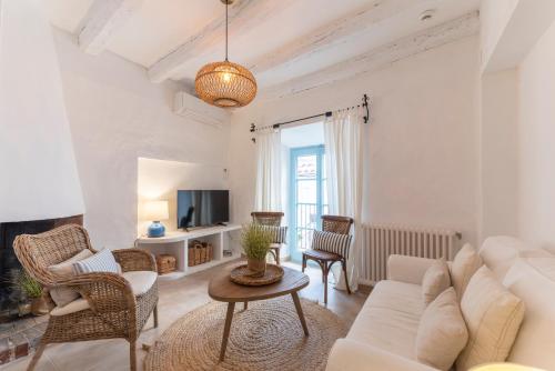 un soggiorno con divano e sedie bianchi di Casa Azul by Hello Homes Sitges a Sitges