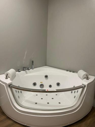 een wit bad in een hoek van een kamer bij بيت عطلات مفروش بالخبر in Al Khobar