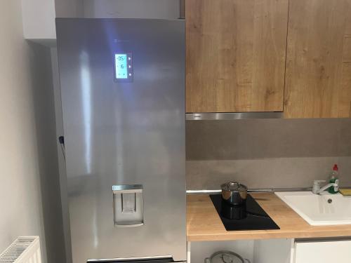 a stainless steel refrigerator in a kitchen with a sink at DISTRiCT 01 - Kalamaria in Thessaloniki