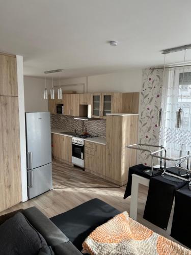 una cocina con armarios de madera y electrodomésticos de acero inoxidable en Sweet Dream Guesthouse en Szeged
