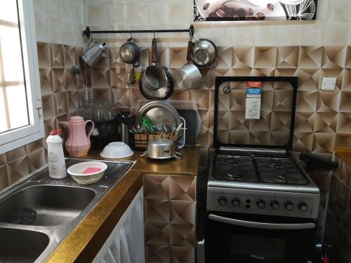 a kitchen with a stove and a sink at شاليه ليالي السيب in Seeb