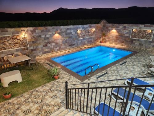 einen Pool mit einer Terrasse, einem Tisch und Stühlen in der Unterkunft Royal Mountain in Luxor