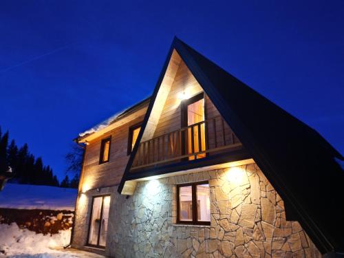 a stone house with lights on it at night at Vila Suvo vrelo sa unutrašnjim bazenom i saunom Jahorina in Jahorina