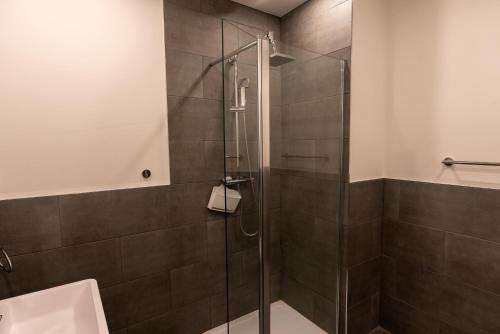 a shower with a glass door in a bathroom at Dockers Inn in London