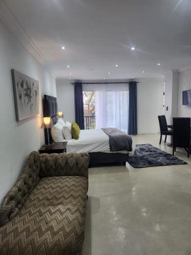 a large hotel room with a bed and a couch at Le Bamboo Guest House And Boat Cruise in Hartbeespoort
